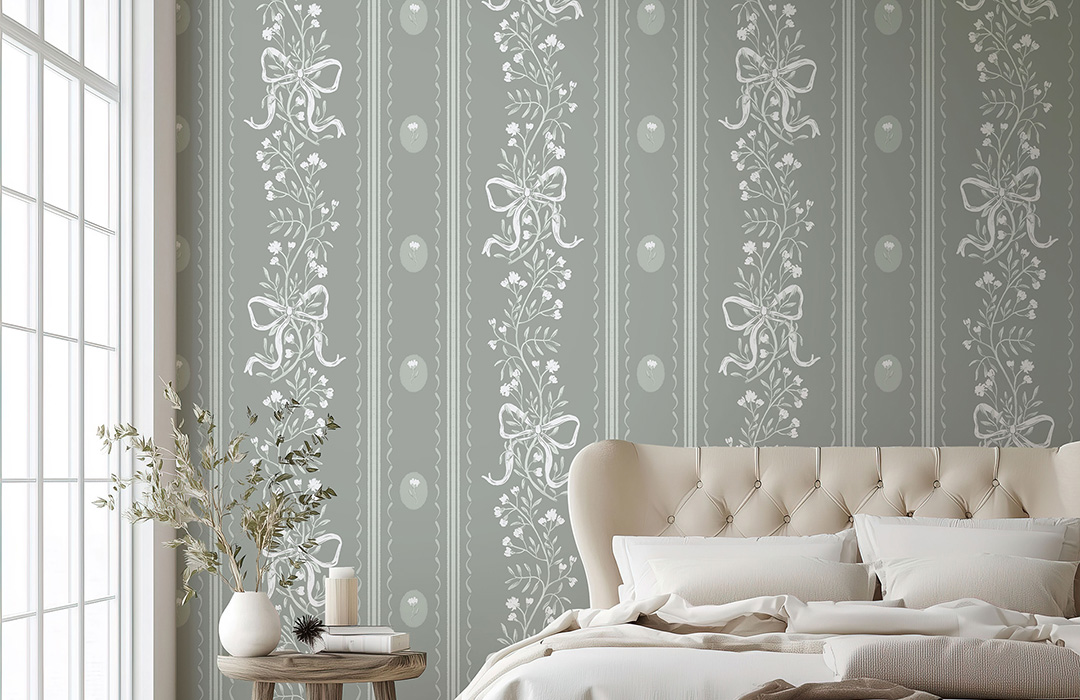Elegant trailing floral wallpaper in sage green and cream, featuring bows, set in a preppy grandmillennial bedroom with a plush bed and natural light